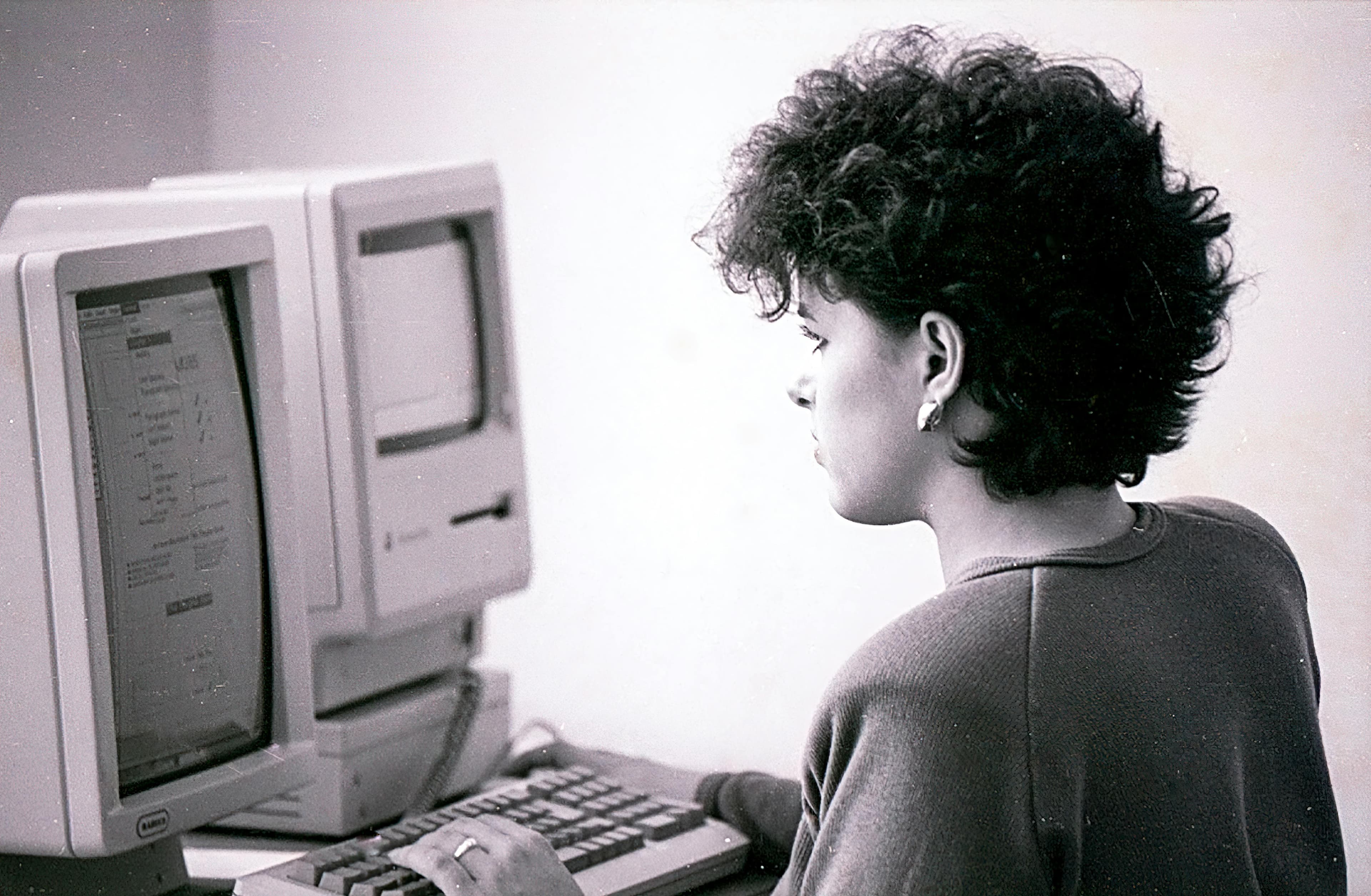 Person working at a vintage computer terminal