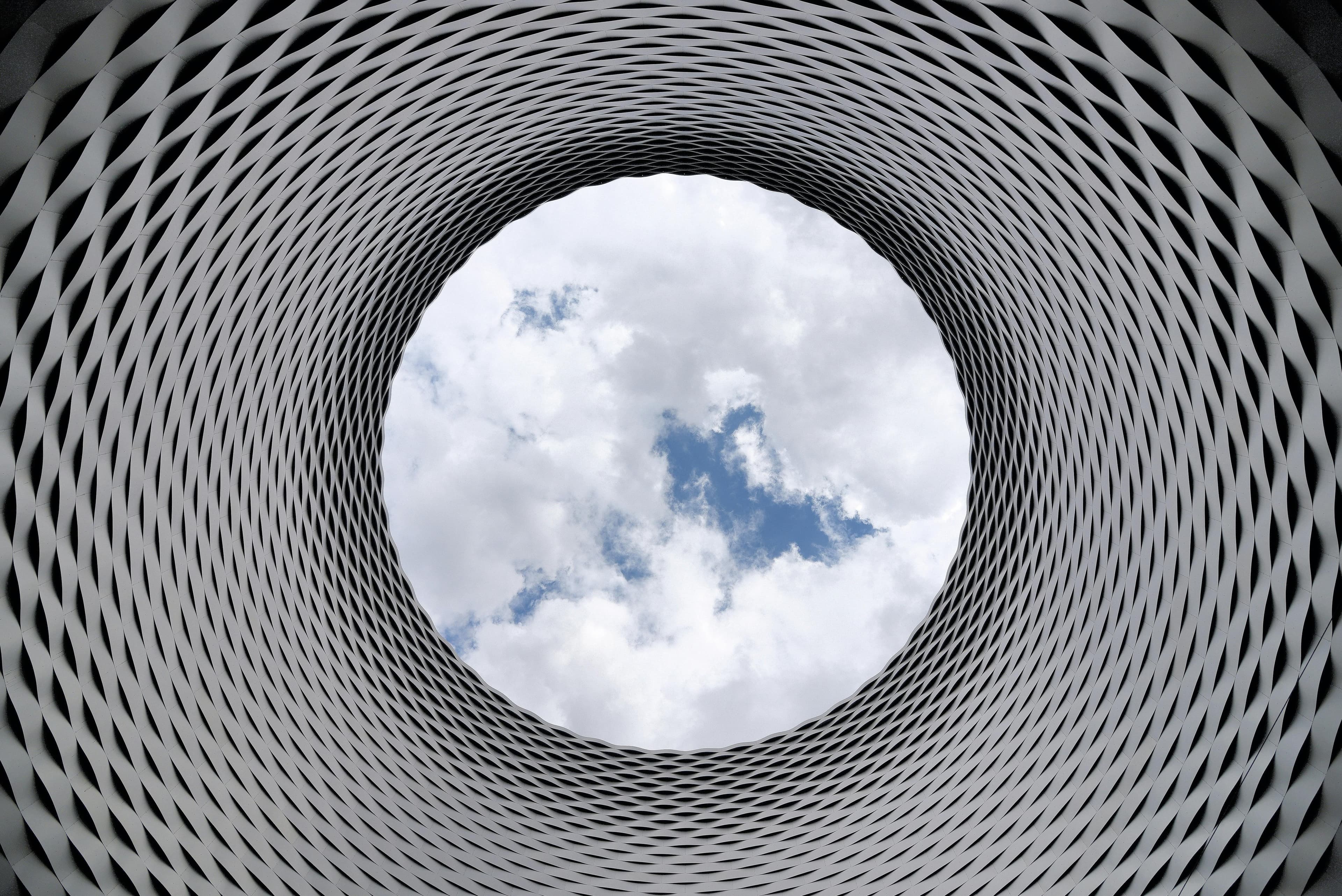 Looking up through a circular architectural structure at the sky